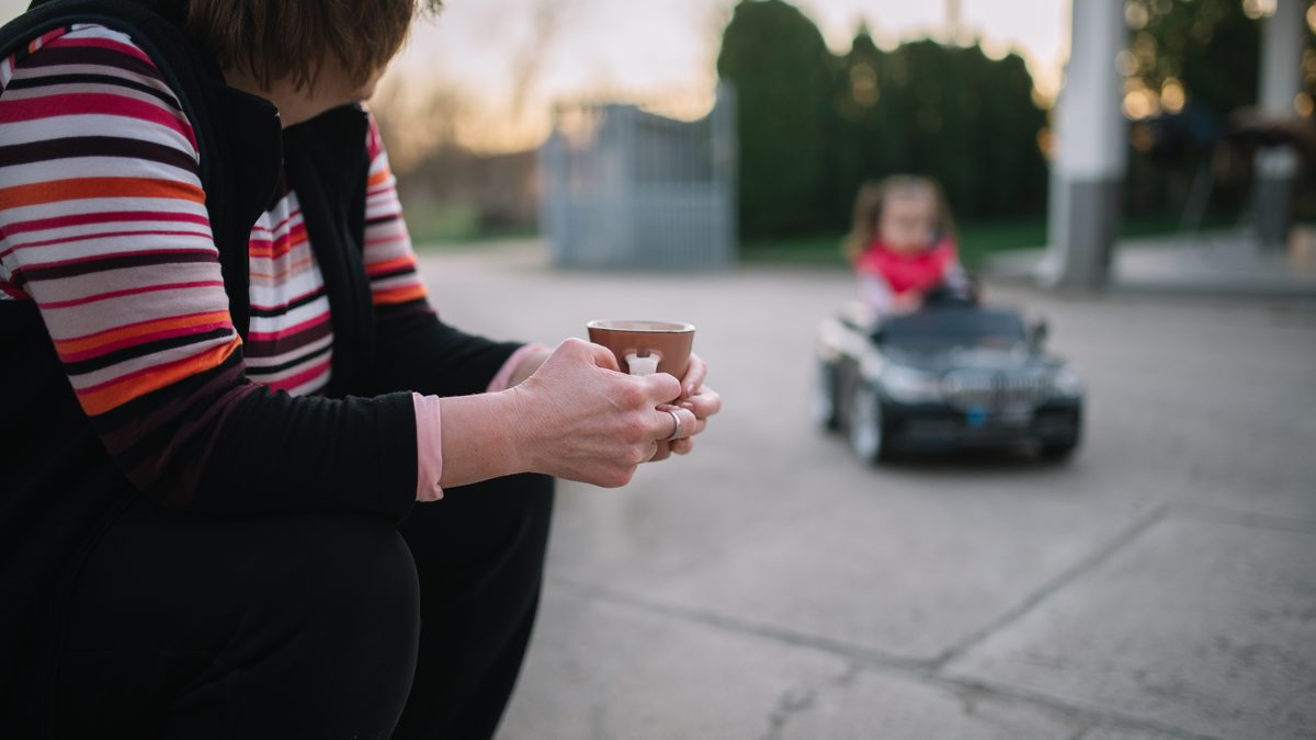 A grandparent watching a child play with a toy car